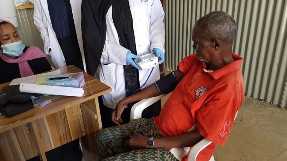 HDC clinician checking a patient's blood pressure during a community screening